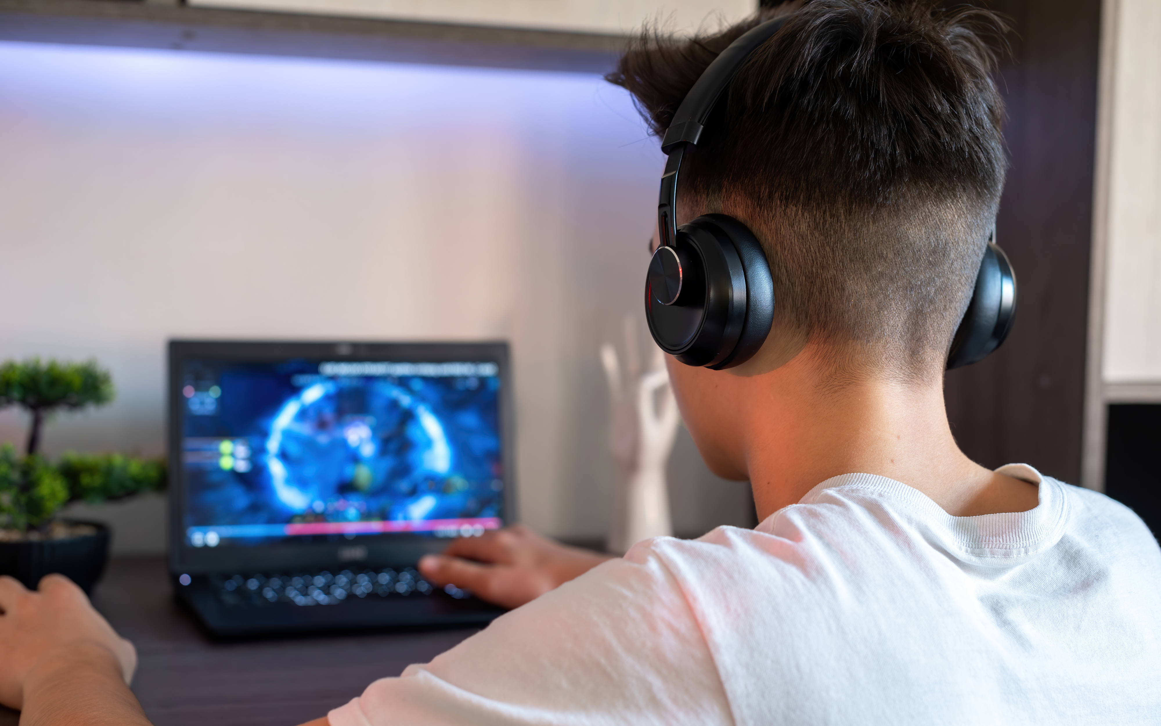 boy wearing headphones playing computer game